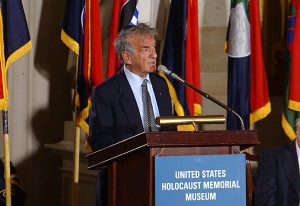 ELIE WIESEL standing at a podium delivering a speech at the U.S. Holocaust Memorial Museum