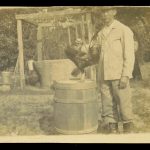 Lue Gim Gong and his pet rooster "March" in front of a well.